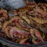 Camarones crudos enteros, con cabeza y antenas, amontonados en una tina con hielo