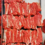 Costillas de res crudas con hueso, cortadas en tiras y acomodadas en hileras