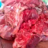 Trozos grandes de carne de res cruda apilados sobre la mesa de madera de una carnicería